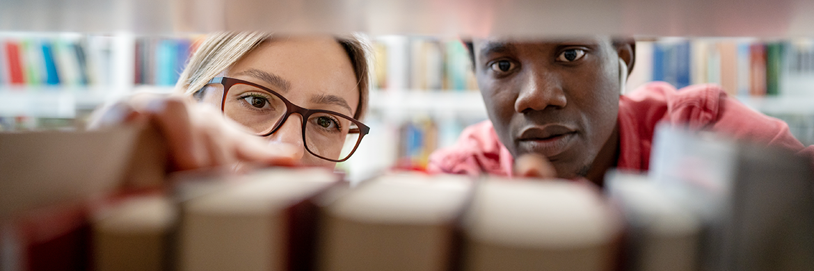 Man and woman looking at books on a shelf