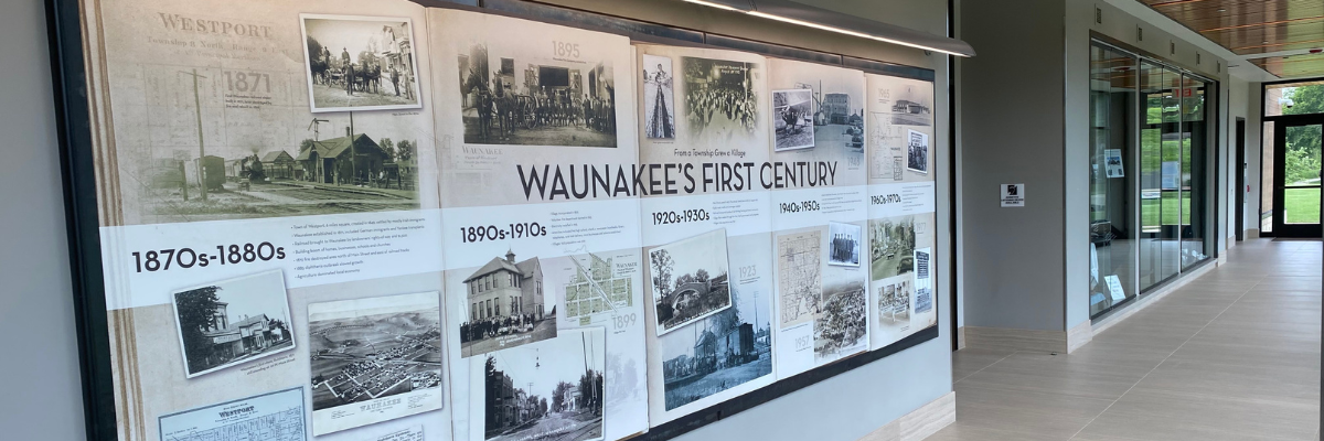 Photo of hallway with sign titled "Waunakee's First Century"