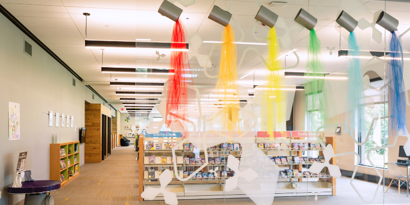 Photo of entrance to kids section with shelves and a coin spinner
