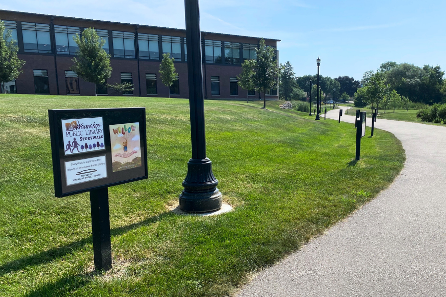 A sign on a path with an image of a book cover on it