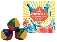 three juggling balls and the book "DIY Circus Lab"