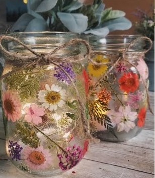 Glass mason jars decorated with pressed flowers and twine 