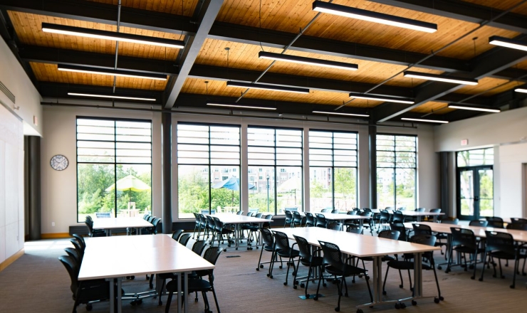 A room with large windows, tables, and chairs